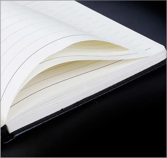 An open notebook with lined pages on a black surface.